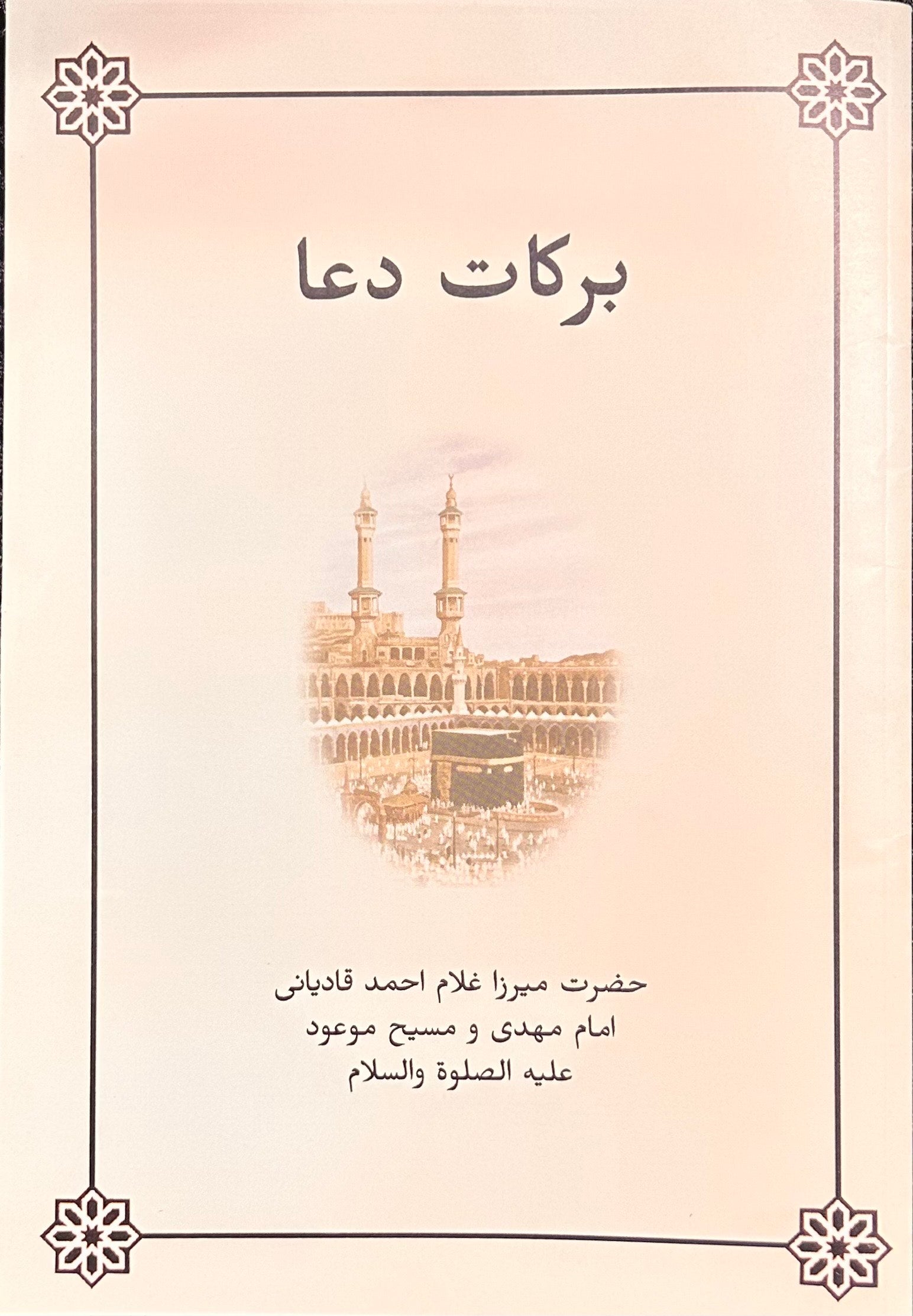 Book cover with farsi text and a illustration of the Kaaba on a light pink background
