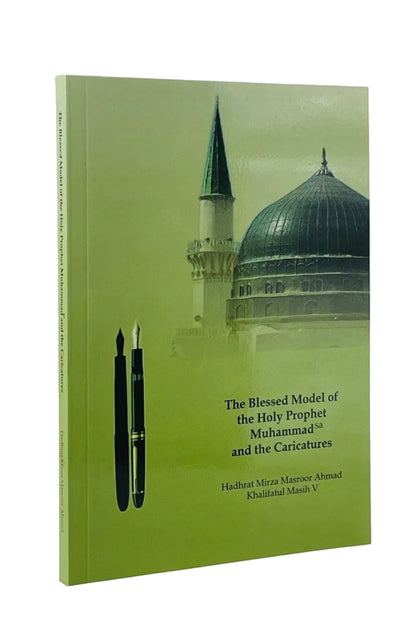 A hardcover book titled 'The Blessed Model of the Holy Prophet Muhammad and the Caricatures' with a light green cover featuring a mosque dome and minaret, two black fountain pens, and author names Hadhat Mirza Masroor Ahmad and Qudratul Maash V, shown on a white background.