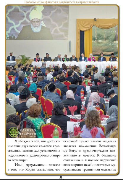 Large gathering of people at a conference or meeting with a speaker on a stage.