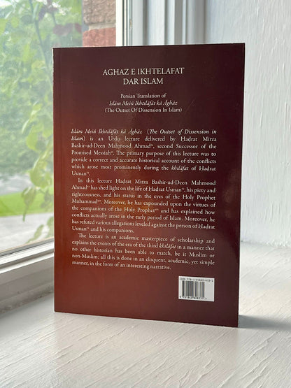 Back cover of a book titled 'Aghaz e Ikhtelafat Dar Islam' with text on a wooden surface.