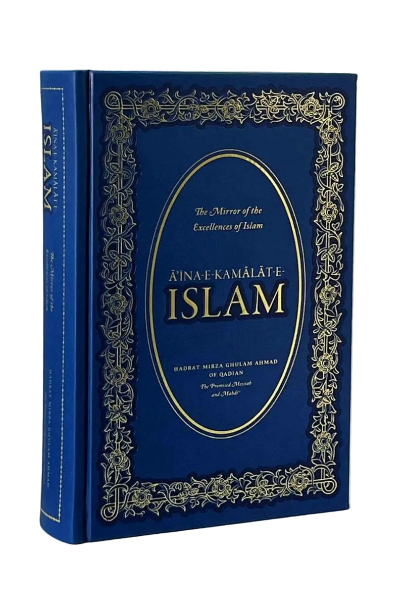 A hardcover book titled 'Ainak Kamalate Islam' in deep blue with ornate gold foil detailing and a gold oval emblem on the front cover, photographed against a neutral light gray background.
